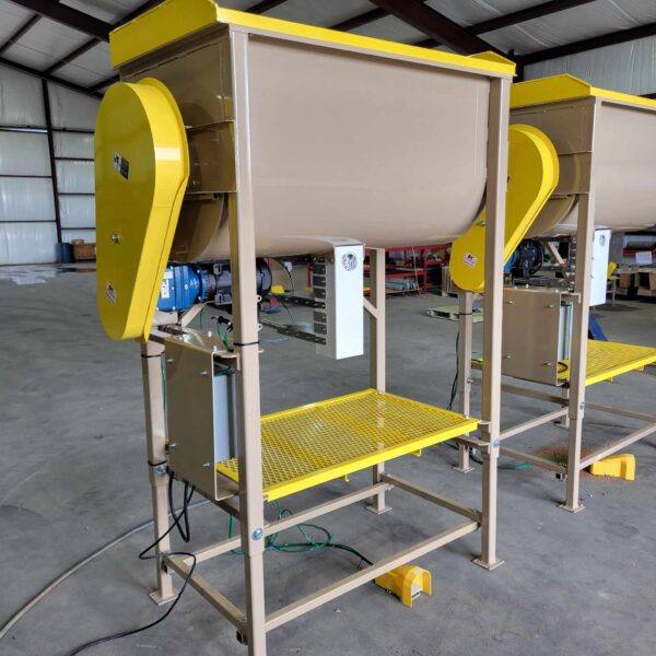 Industrial Batch Mixers with beige body, yellow details, and attached motor, housed in a workshop setting.
