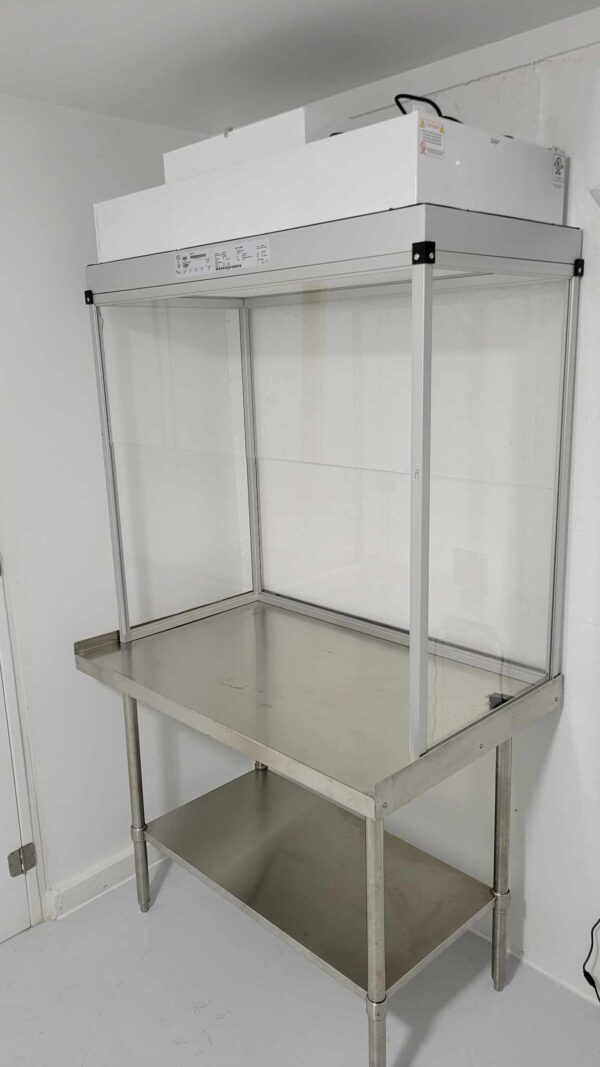 A stainless steel table with a glass shelf fitted in a room, featuring a Vertical Flow Cabinet 2x4 ft Flowhood Fan Filter Unit New 120V *Freight Not Included* for enhanced ventilation.