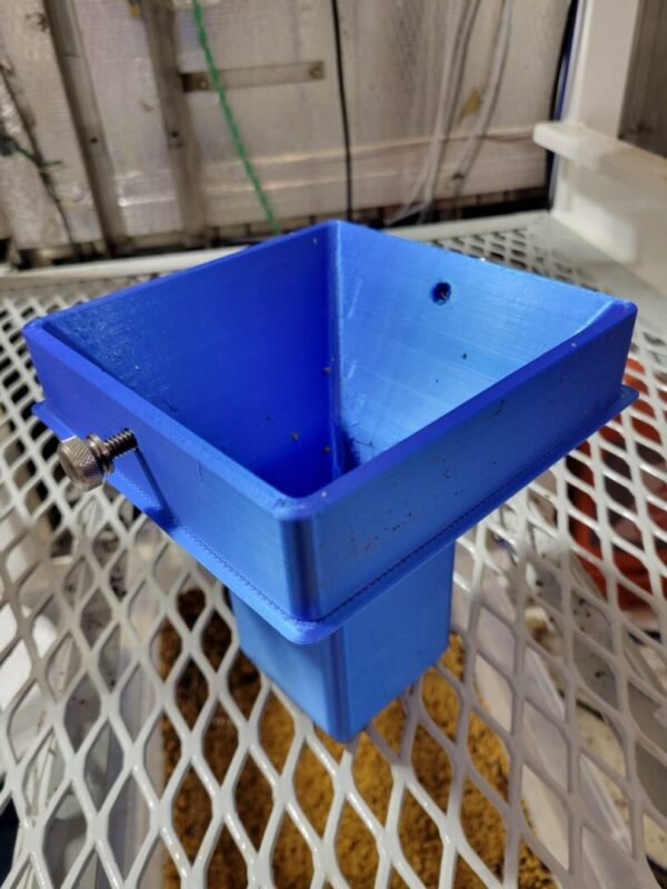A blue plastic container sitting on top of a metal plate.