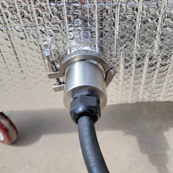 A silver hose connected to a metal Stainless Steel Grain Spawn Tank.