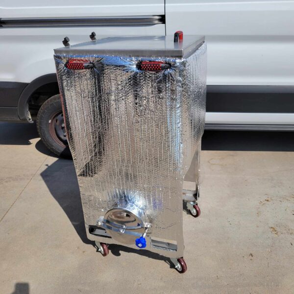 A silver cooler on wheels, known as a Stainless Steel Grain Spawn Tank, is positioned in front of a van.